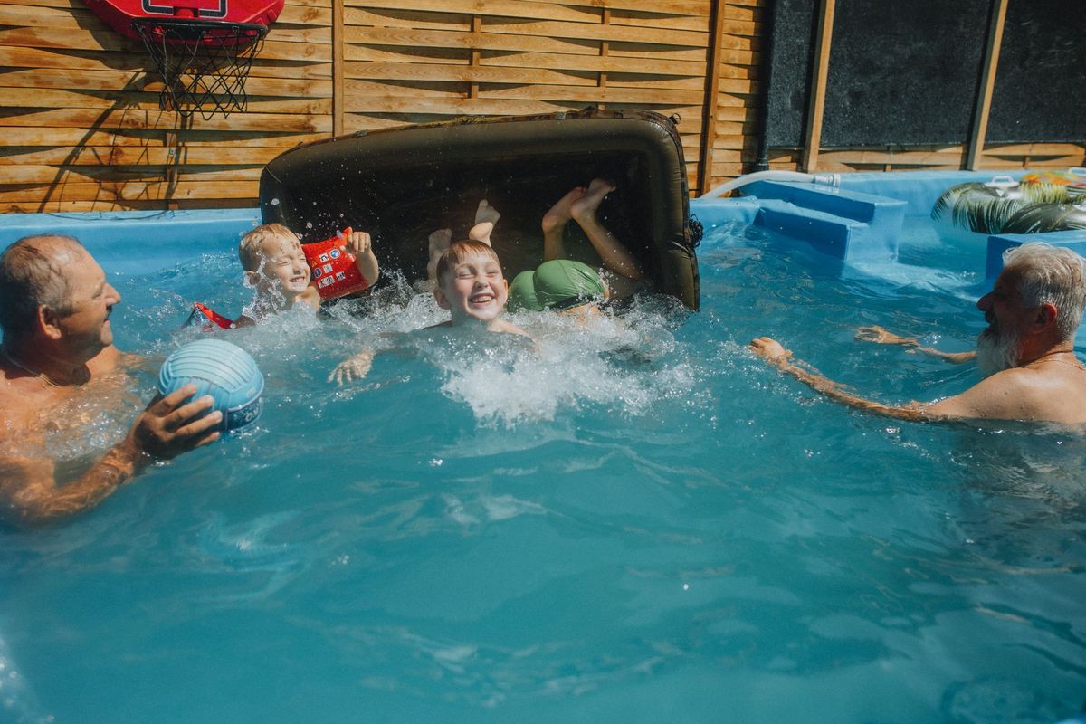 A family playing in a backyard pool