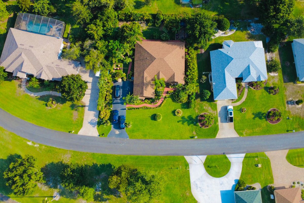 Aerial view of a residential street with houses and gardens