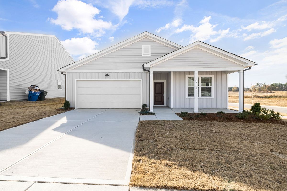 A new single-story house with a garage and a front lawn