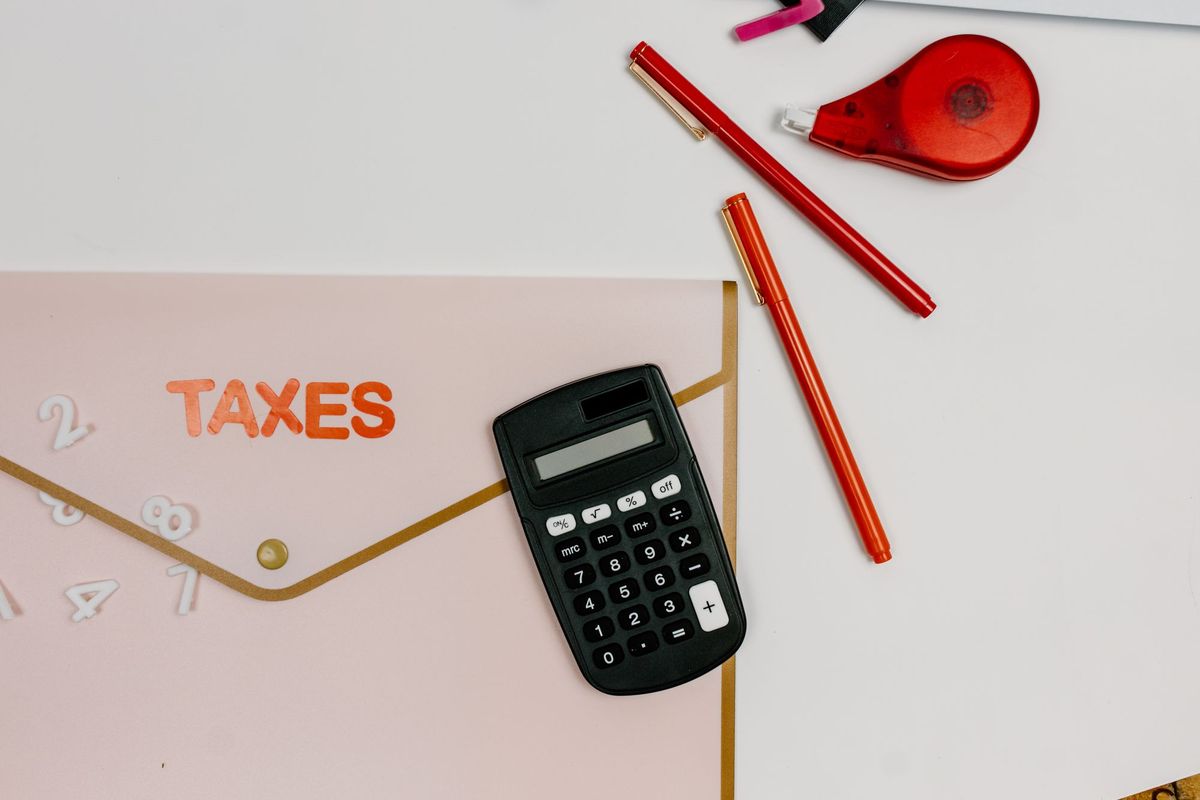 A calculator and a folder marked Taxes on a desk