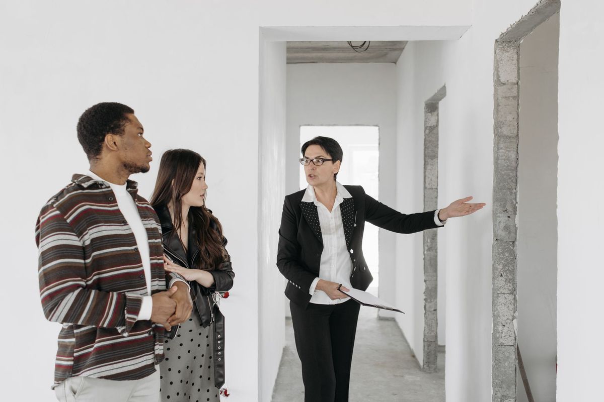 A real estate agent showing a couple around a newly built home
