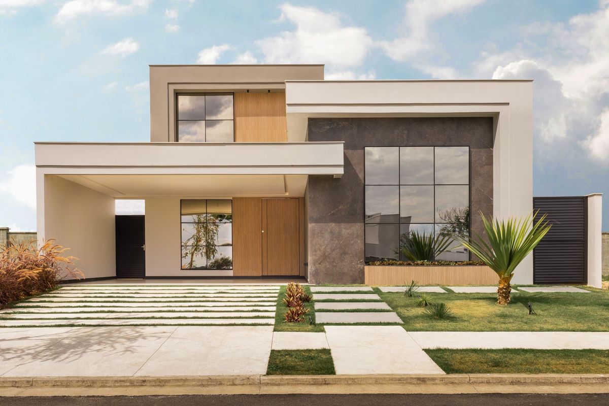 A modern house with large windows and a landscaped front yard