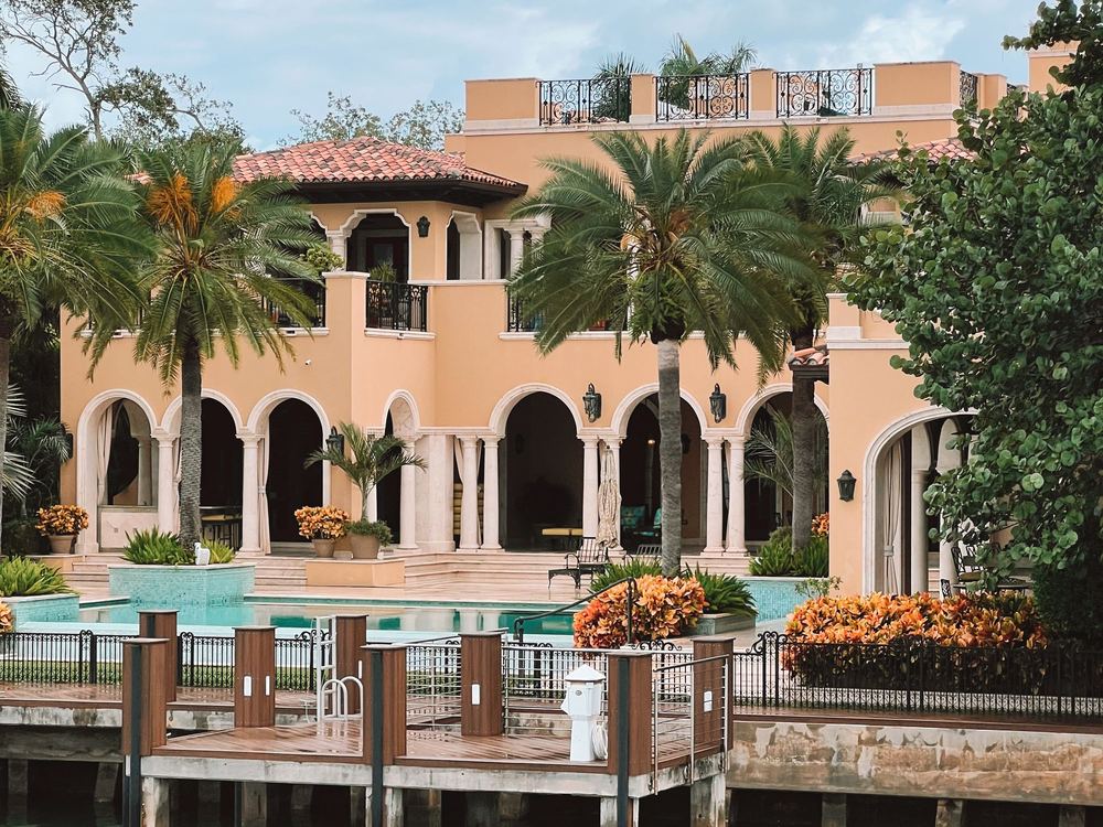 Mediterranean-style waterfront house with palm trees