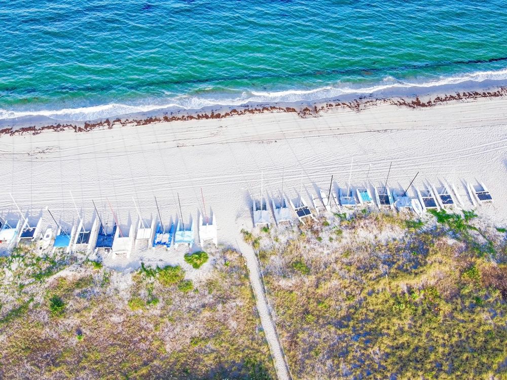 The public beach in Delray Beach from above, with rows of umbrellas and chairs