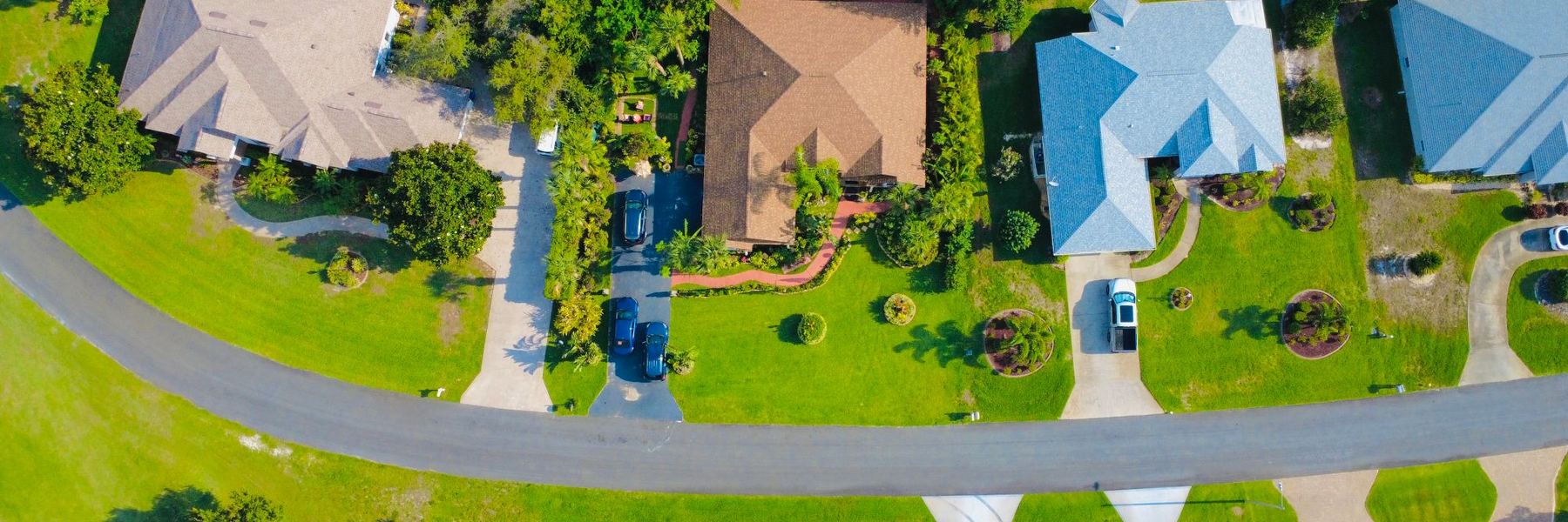 Aerial view of a residential street with houses and gardens