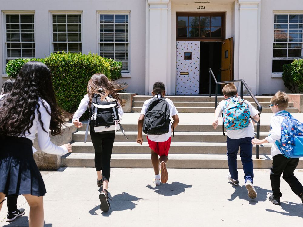 Students with backpacks heading into school