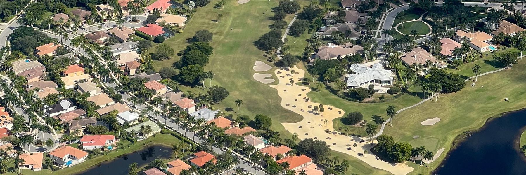 Aerial view of a residential community with lakes and a golf course in Florida